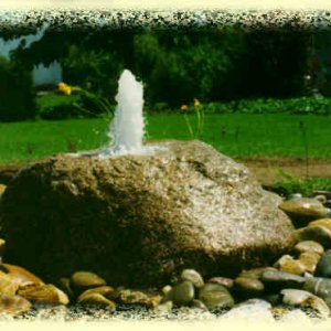 Granit-Findling als Quellstein mit Oberrhein-Kiesbett