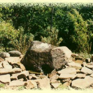 Basalt-Findling als Quellstein mit Bett aus Bruchsteinen